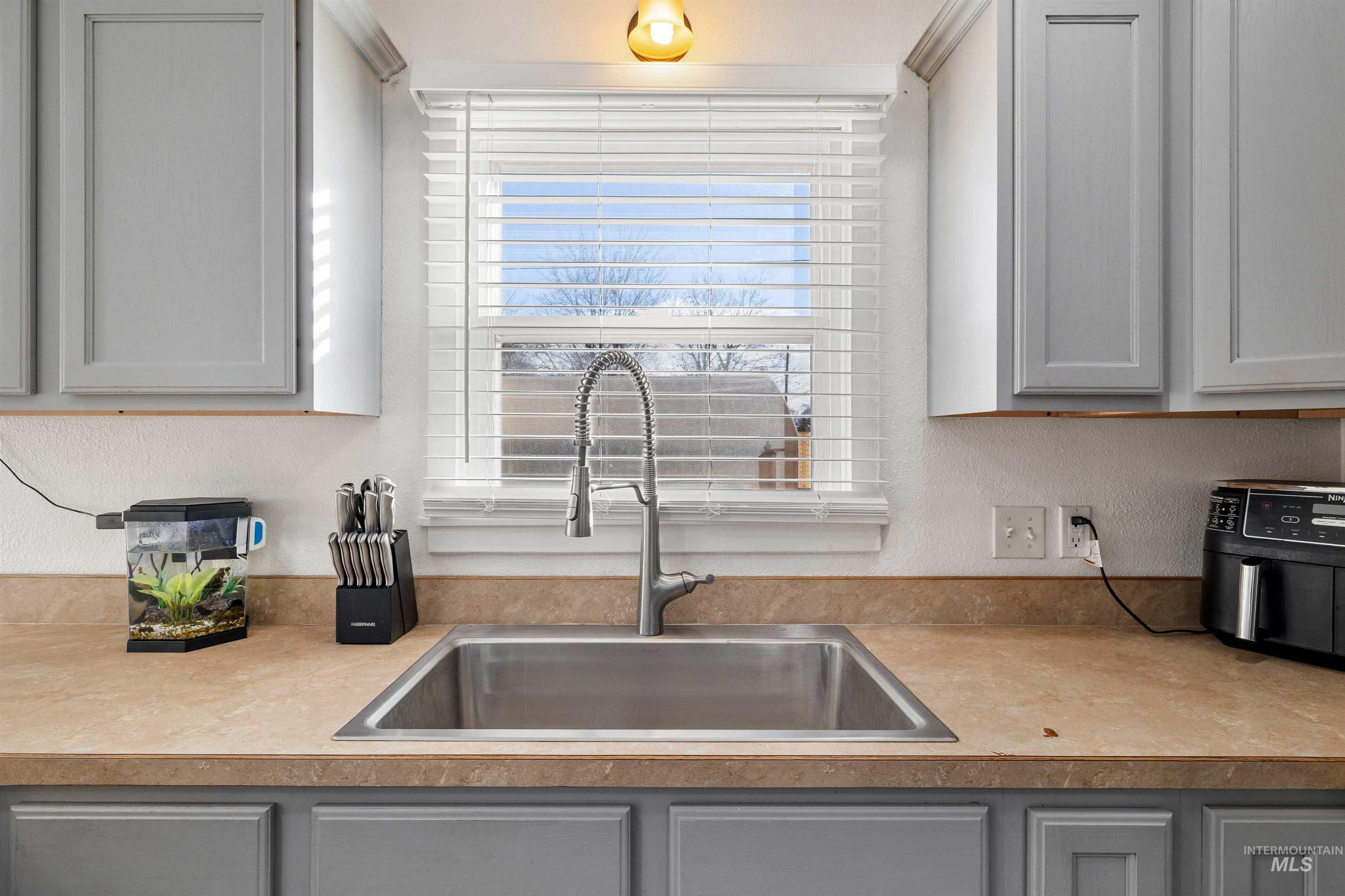 753 Ash Street Twin Falls, ID 83301 - Photo 7 of 25 Kitchen with gray cabinets, light countertops, and a textured wall