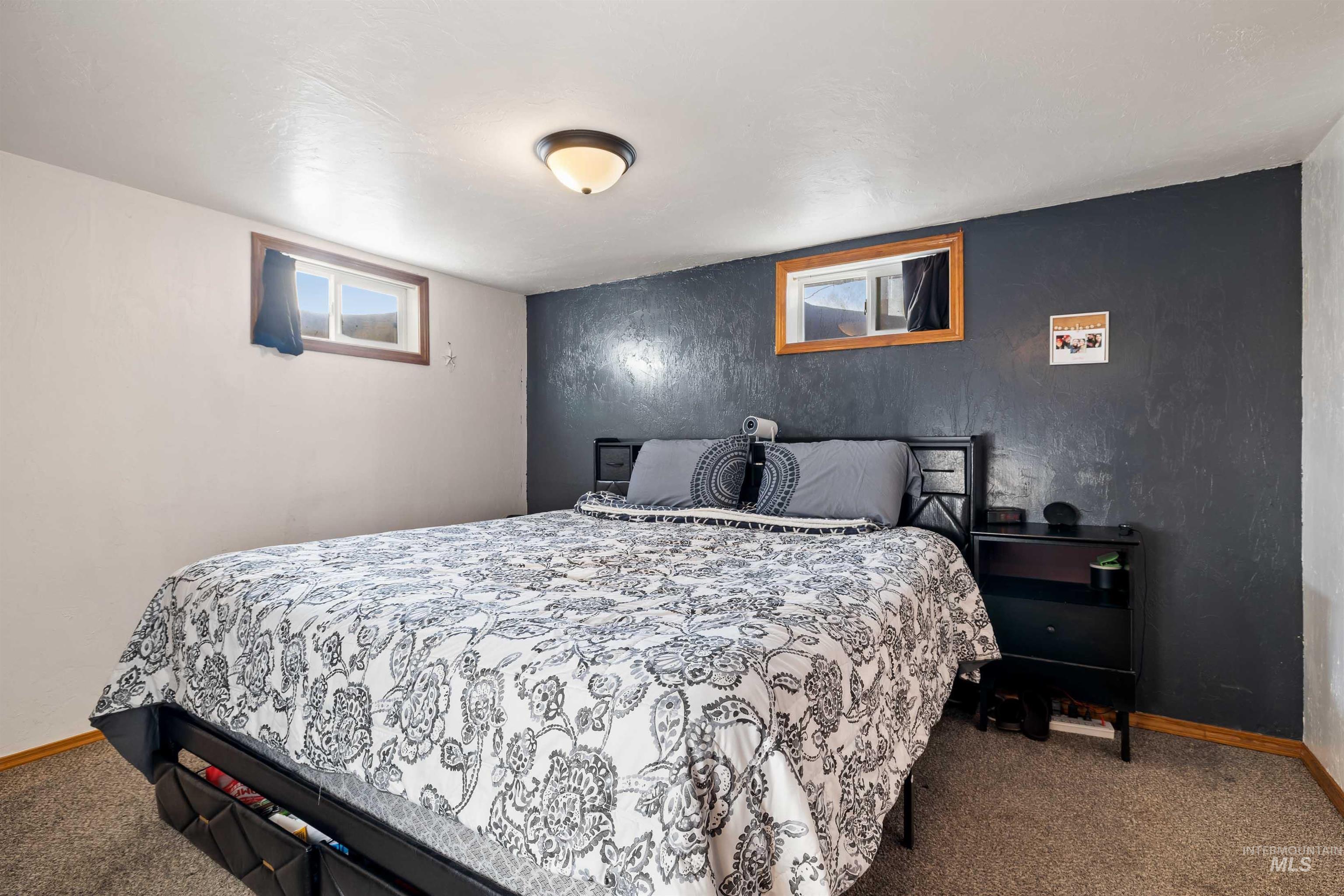 753 Ash Street Twin Falls, ID 83301 - Photo 10 of 25 Bedroom featuring carpet floors, an accent wall, and multiple windows