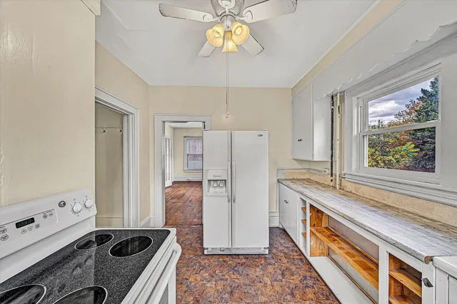 a view of a hallway with wooden floor and a bathroom