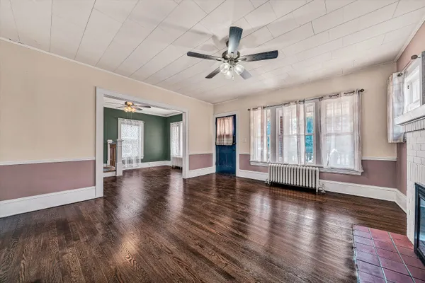 a view of a hallway with wooden floor and staircase