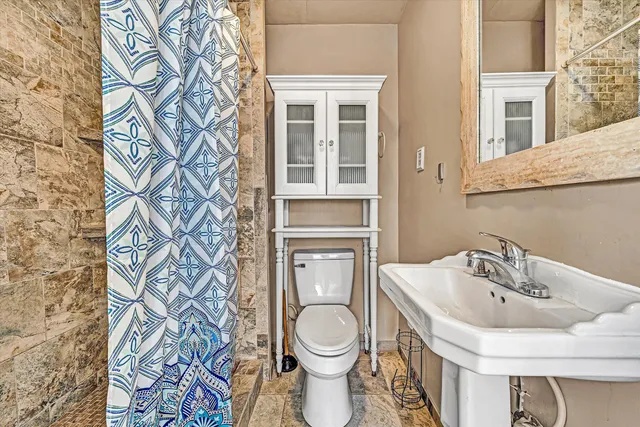 a bathroom with a granite countertop tub sink and mirror