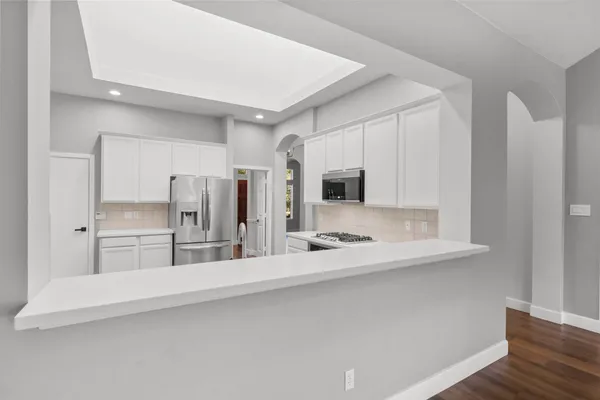 a kitchen with stainless steel appliances granite countertop a sink stove and refrigerator