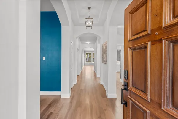 a view of a hallway with wooden floor and staircase