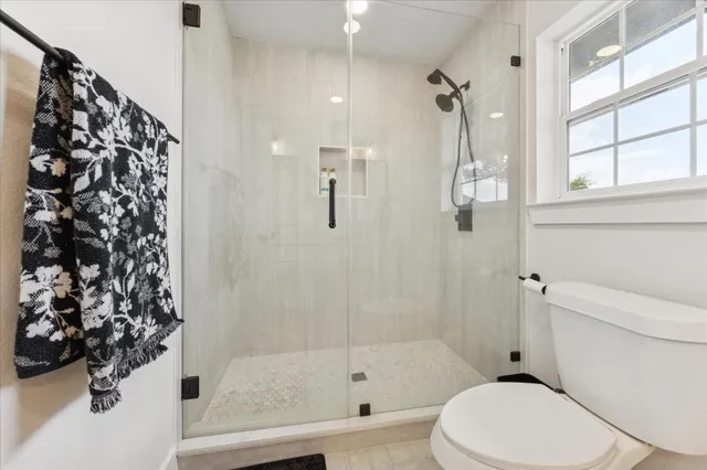 a bathroom with a toilet and a shower