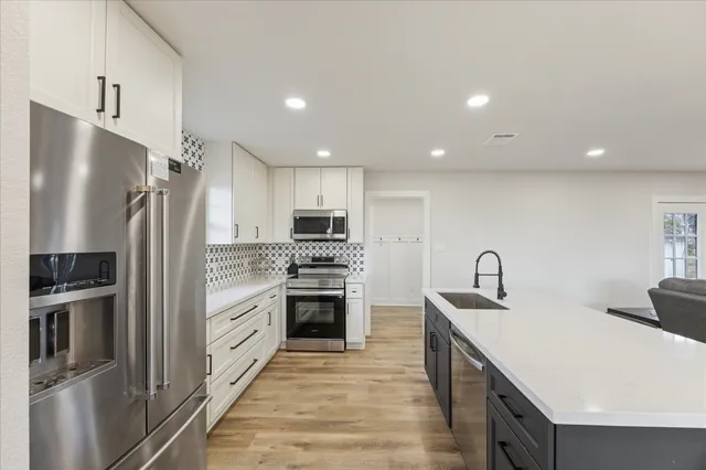 a kitchen with stainless steel appliances a refrigerator sink and stove