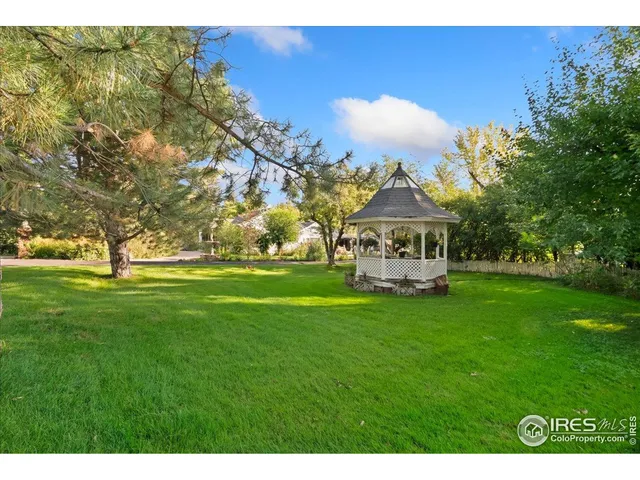 a view of a big house with a big yard and large trees