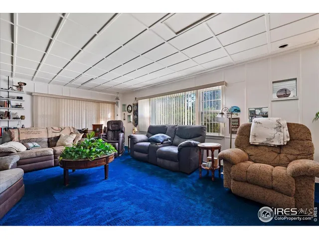a living room with furniture a window and a flat screen tv