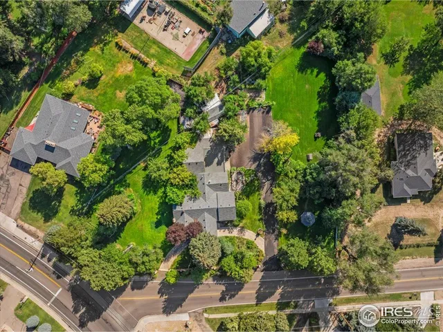 an aerial view of a residential apartment building with a yard and garden space