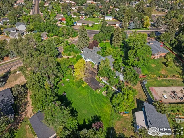 an aerial view of residential houses with outdoor space and trees