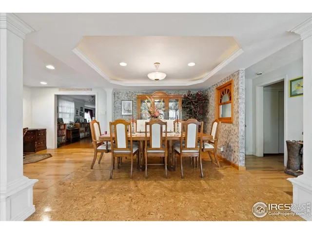 a living room with lots of white furniture a chandelier and a painting