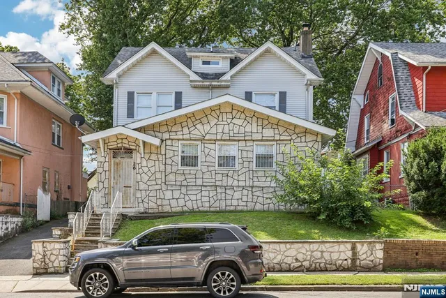 a front view of a house with a garden