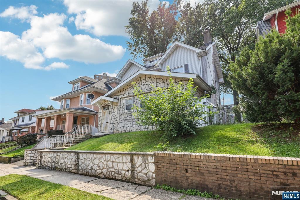 28 Scheerer Avenue Newark, NJ 07112 - Photo 2 of 39 a view of a brick house next to a yard with big trees