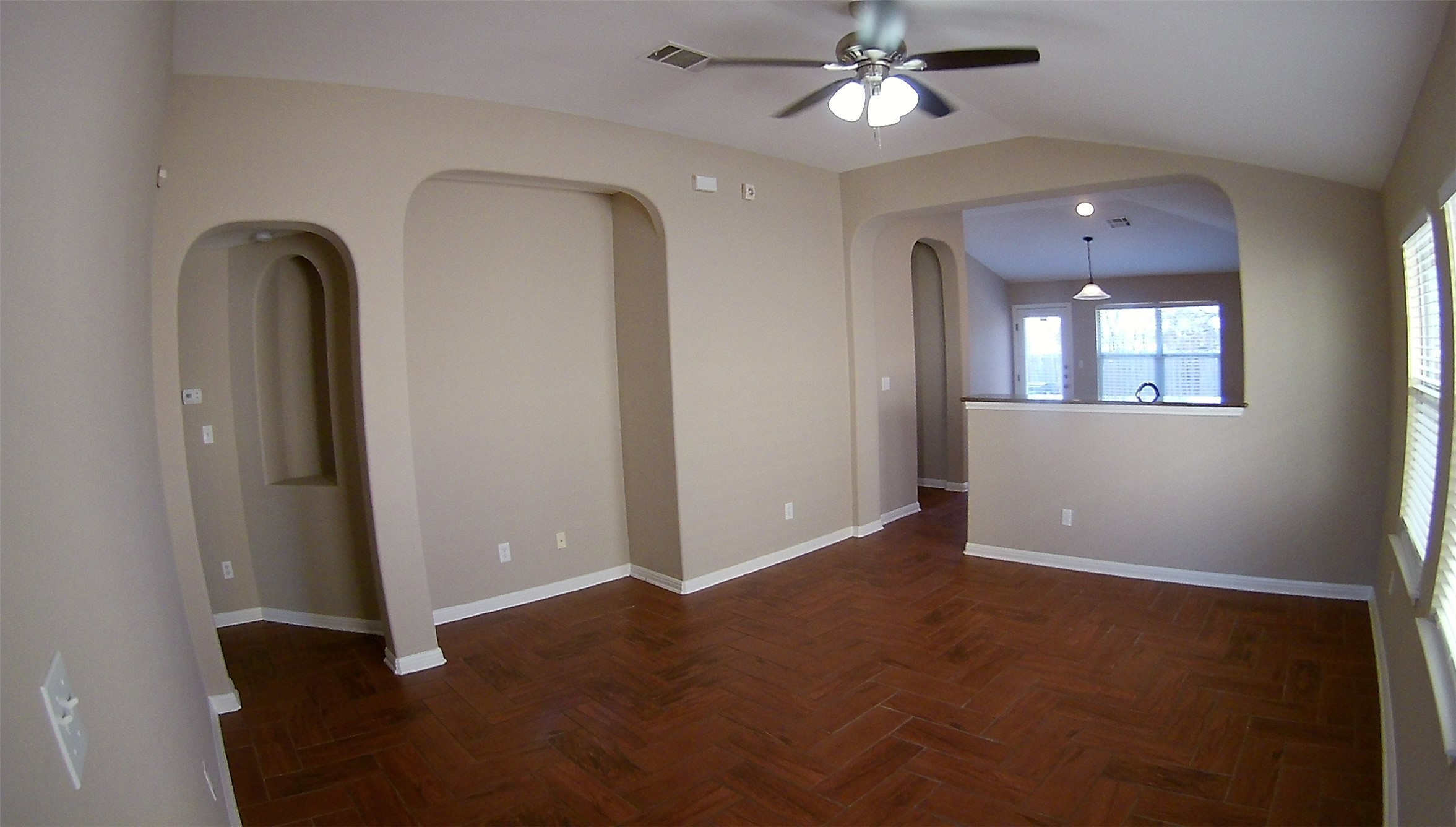 3304 Wickham Lane Austin, TX 78725 - Photo 12 of 13 Empty room featuring lofted ceiling, parquet flooring, a ceiling fan, and arched walkways