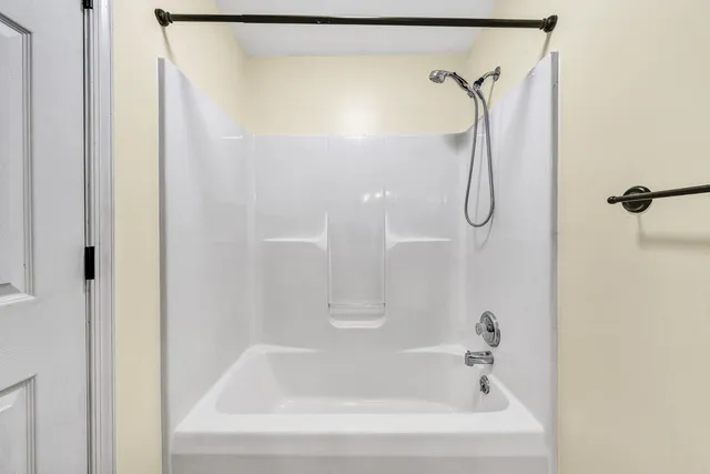 a bathroom with a bath tub with a shower