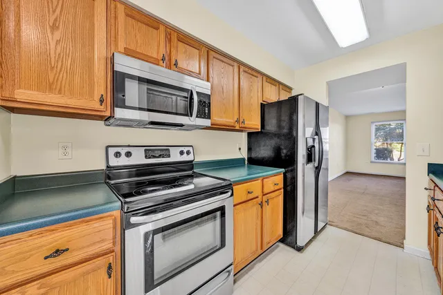 a kitchen with stainless steel appliances granite countertop a refrigerator stove and sink