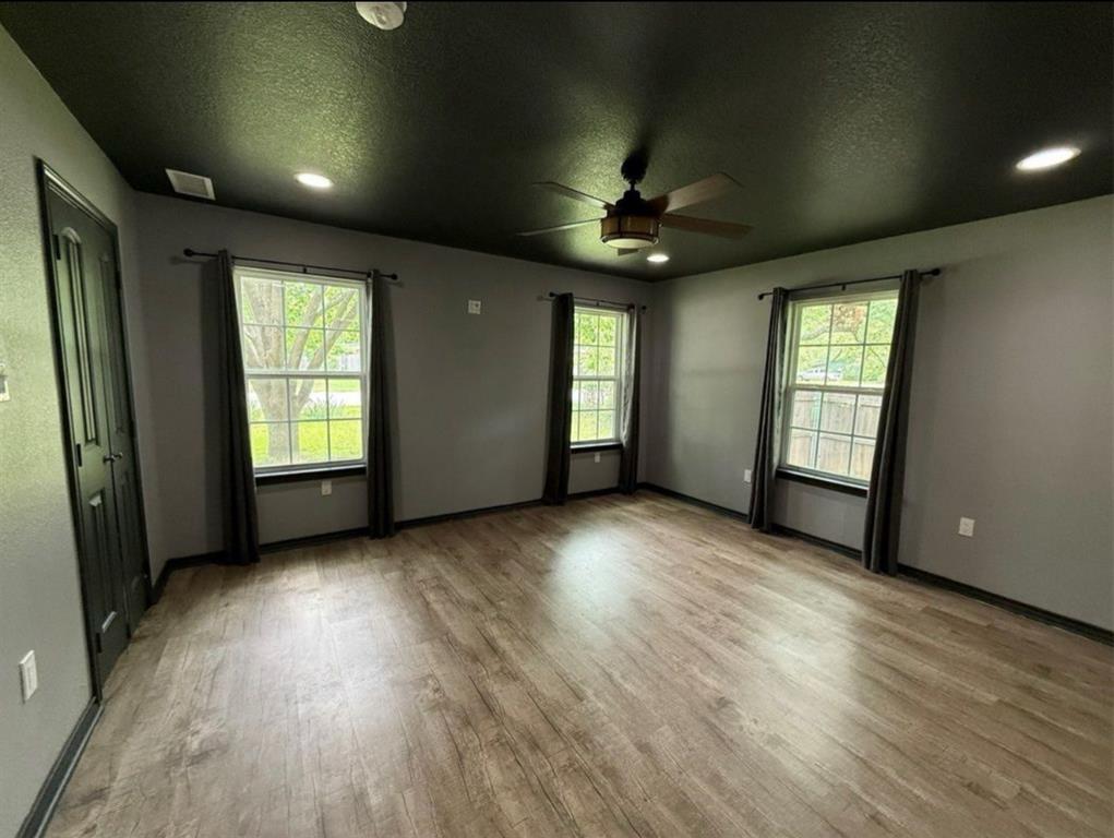 400 North Ave A Springtown, TX 76082 - Photo 16 of 19 an empty room with wooden floor and windows