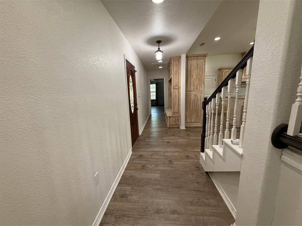 400 North Ave A Springtown, TX 76082 - Photo 9 of 19 a view of a hallway with wooden floor and staircase