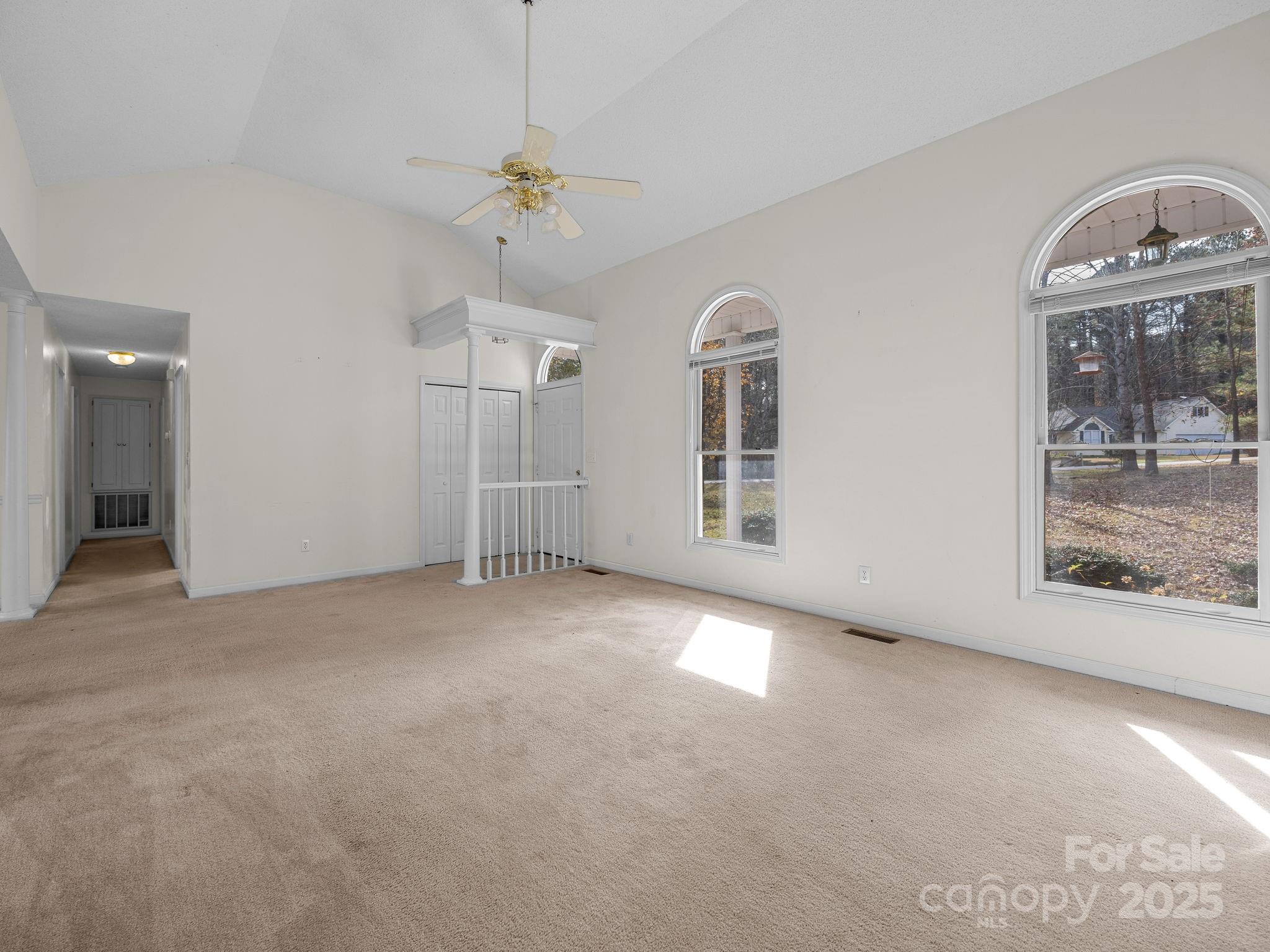 383 Woody Circle Tryon, NC 28782 - Photo 11 of 36 an empty room with chandelier fan and windows