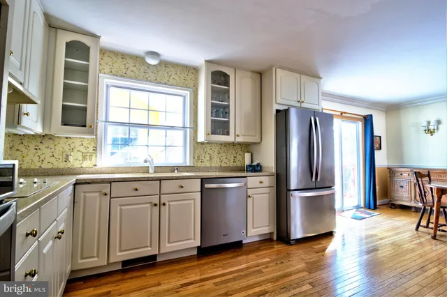 a kitchen with granite countertop appliances a sink cabinets and a large window
