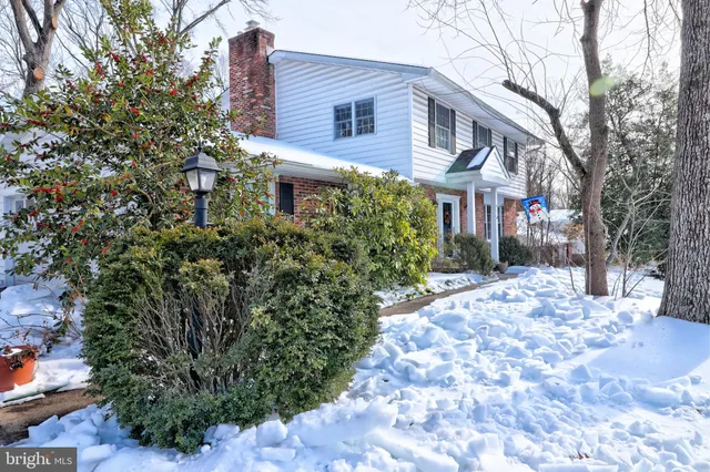 a front view of a house with a yard covered with snow