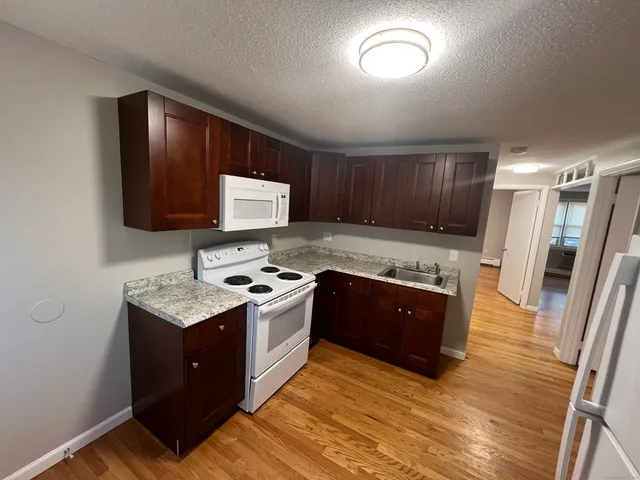 a kitchen with granite countertop stainless steel appliances and wooden cabinets