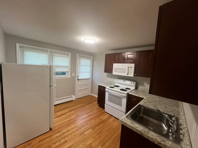 a kitchen with granite countertop a stove and a refrigerator