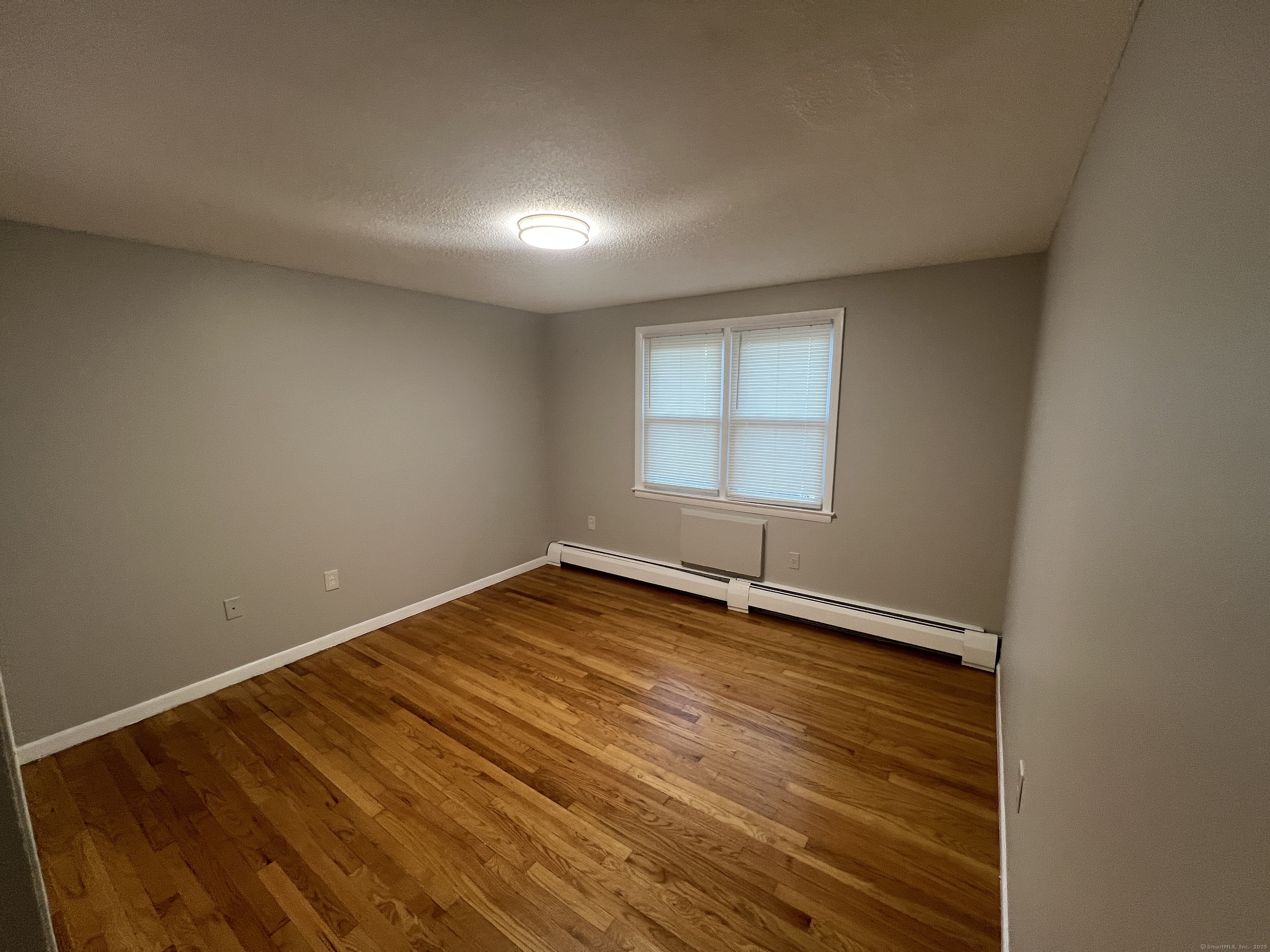 119 Frederick Street, Unit 2R New Haven, CT 06515 - Photo 7 of 14 an empty room with wooden floor and windows