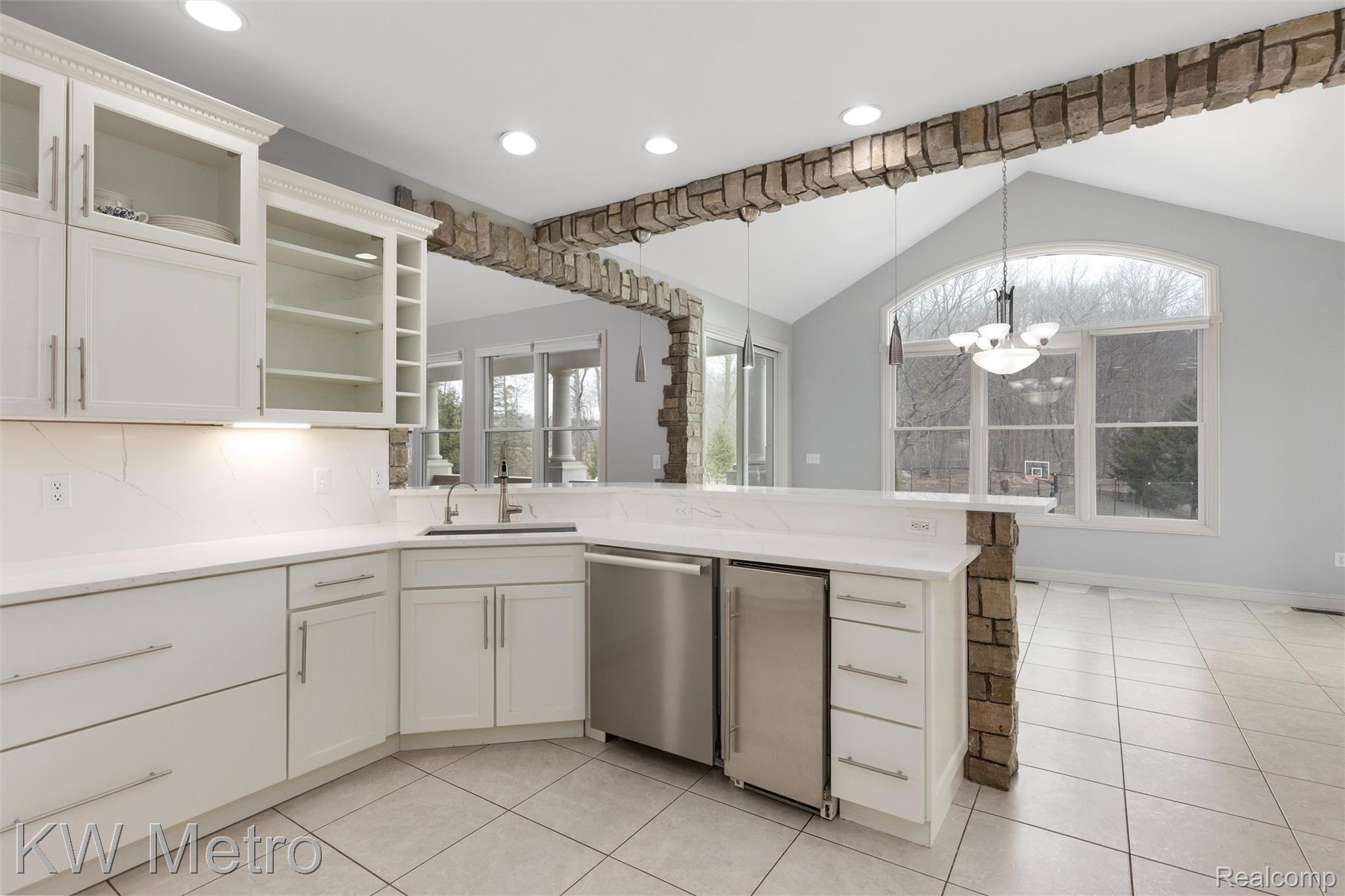 65884 Windrose Court Ray, MI 48096 - Photo 37 of 82 Kitchen featuring a peninsula, stainless steel dishwasher, white cabinetry, and light tile patterned floors