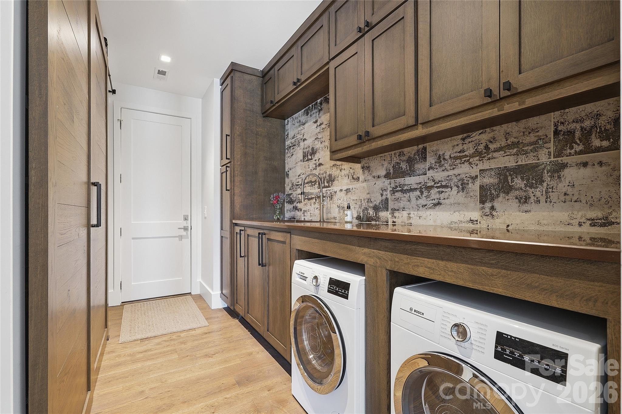 984 Mapleton Lane Tryon, NC 28782 - Photo 22 of 47 a utility room with granite countertop a sink a washer and dryer