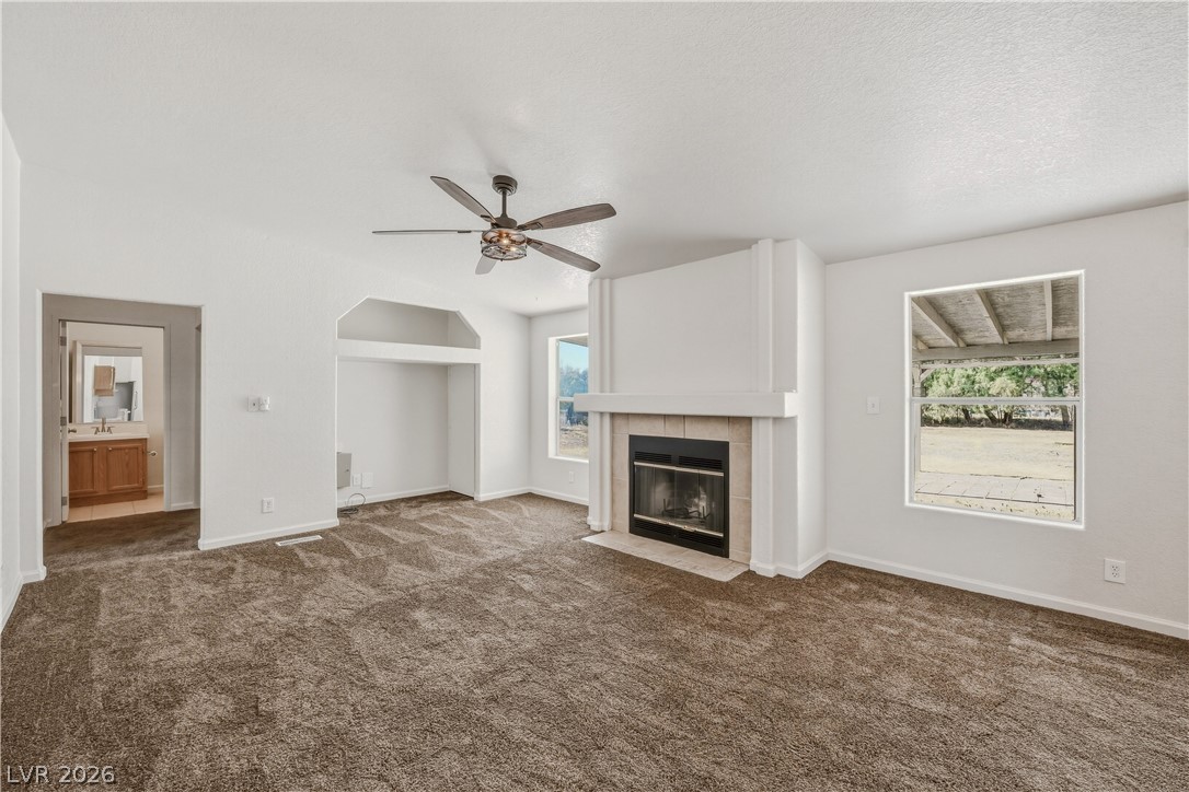 1890 West Dyer Road Pahrump, NV 89048 - Photo 4 of 40 This spacious living area features a cozy fireplace and inviting carpet, perfect for comfortable gatherings.