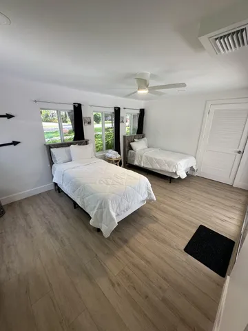 a bedroom with a bed window and wooden floor