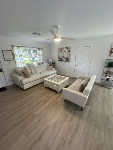 a living room with furniture and a wooden floor