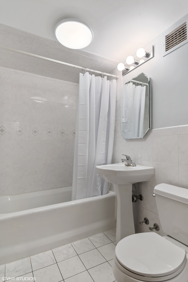737 Ridge Avenue, Unit 1L Evanston, IL 60202 - Photo 9 of 14 a bathroom with a toilet a sink and bathtub