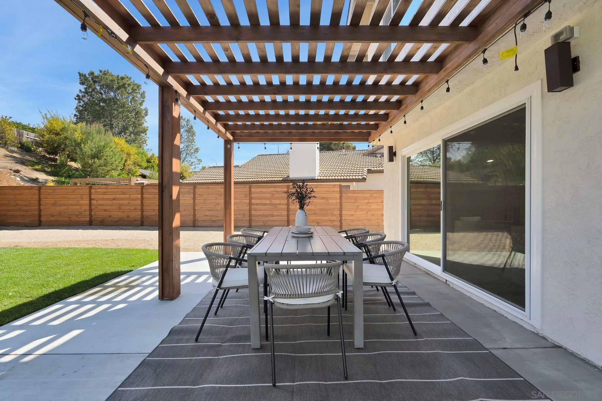 7815 Quebrada Circle Carlsbad, CA 92009 - Photo 25 of 32 a view of a patio with table and chairs with wooden floor and fence
