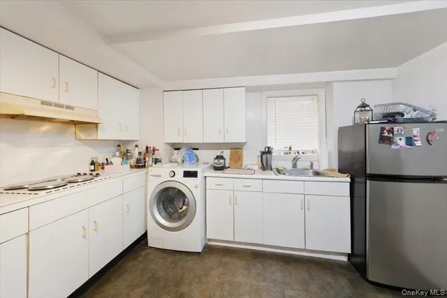 a kitchen with refrigerator a stove a sink and cabinets