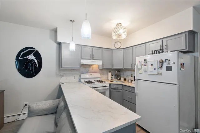 a kitchen with stainless steel appliances granite countertop a sink a stove a refrigerator and island with wooden floor