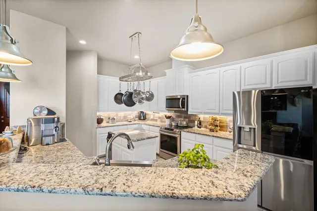 a large kitchen with kitchen island granite countertop a stove and a sink