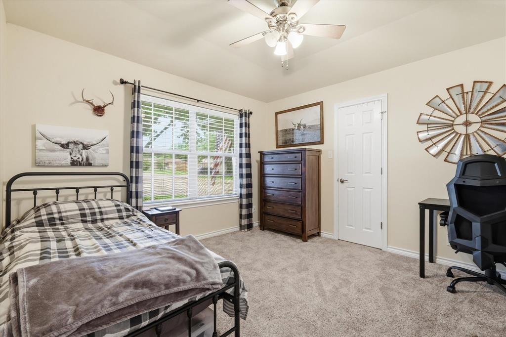 202 Colonial Heights Sanger, TX 76266 - Photo 22 of 27 a bedroom with a bed and a chandelier