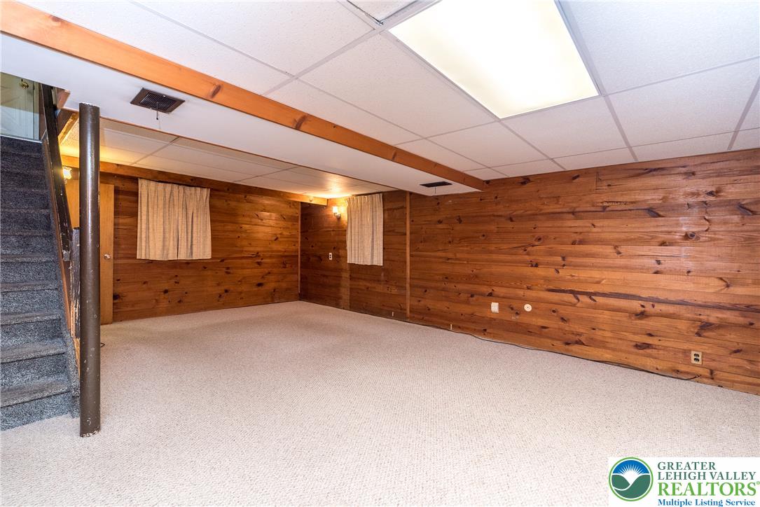 2132 Cypress Road Bethlehem, PA 18018 - Photo 8 of 16 Cozy lower level room offers flexible space, featuring warm wood paneled walls and soft carpet flooring.