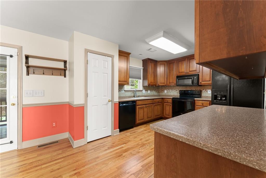 3454 Highway 254 Cleveland, GA 30528 - Photo 11 of 52 a kitchen with stainless steel appliances granite countertop a refrigerator a sink dishwasher a stove with wooden cabinets and floor