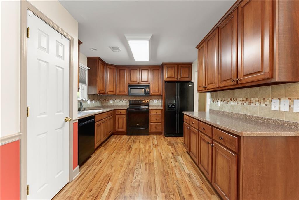 3454 Highway 254 Cleveland, GA 30528 - Photo 10 of 52 a kitchen with granite countertop wooden floors stainless steel appliances a sink and cabinets