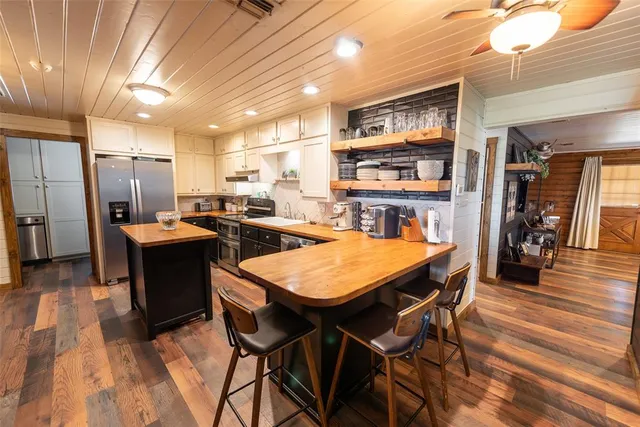 a kitchen with stainless steel appliances kitchen island granite countertop furniture and wooden floor