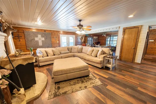 a living room with furniture a flat screen tv and a large window