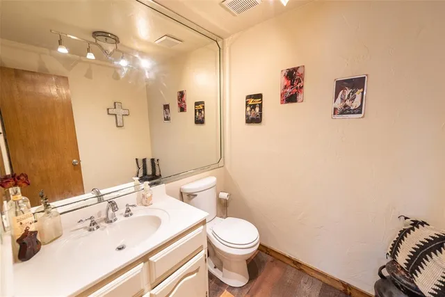 a bathroom with a sink vanity mirror and toilet