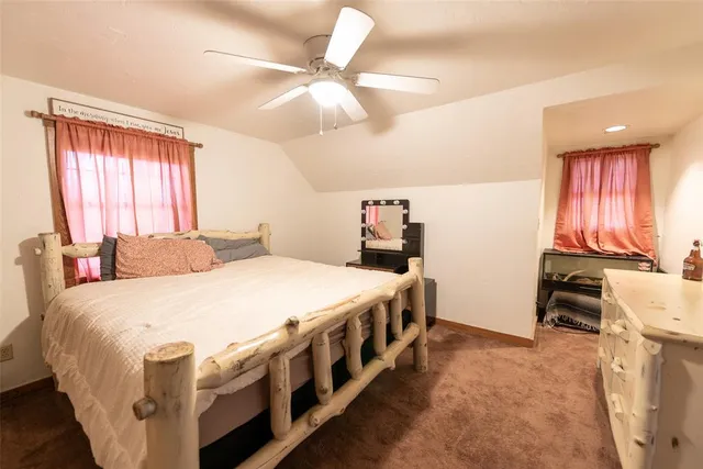 a bedroom with a bed next to a window