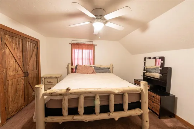 a large bed sitting in a bedroom next to a window