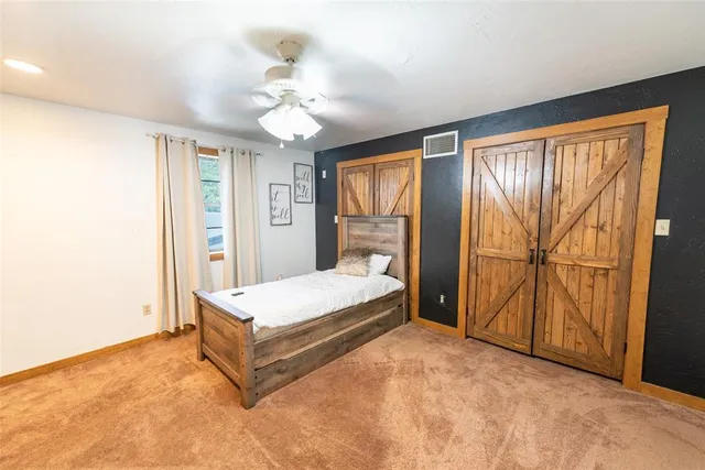 a spacious bedroom with a bed and a chandelier