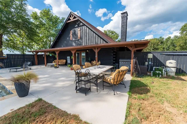 a view of a patio with table and chairs and a barbeque with potted plants