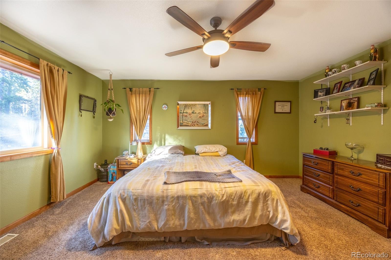 493 Caesar Road Black Hawk, CO 80422 - Photo 13 of 35 a spacious bedroom with a bed and a chandelier