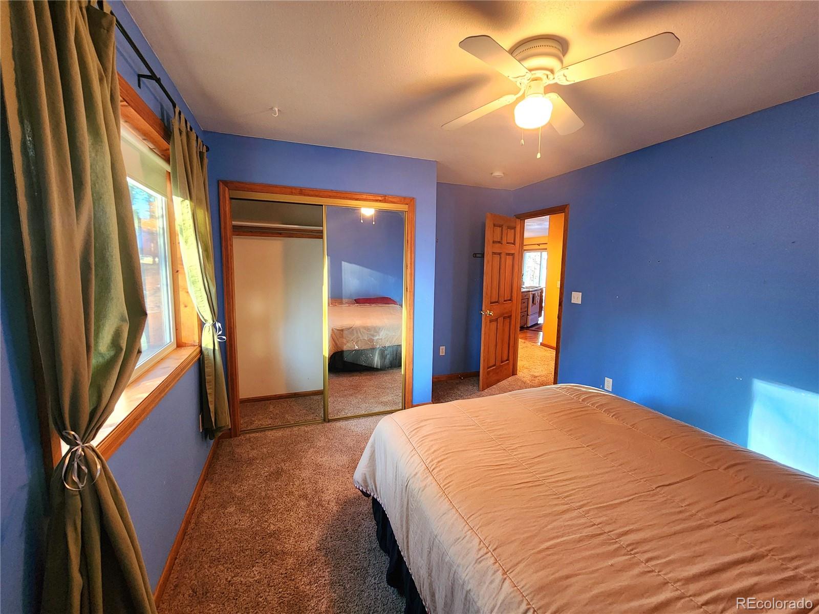 493 Caesar Road Black Hawk, CO 80422 - Photo 19 of 35 a bedroom with a bed and a chandelier